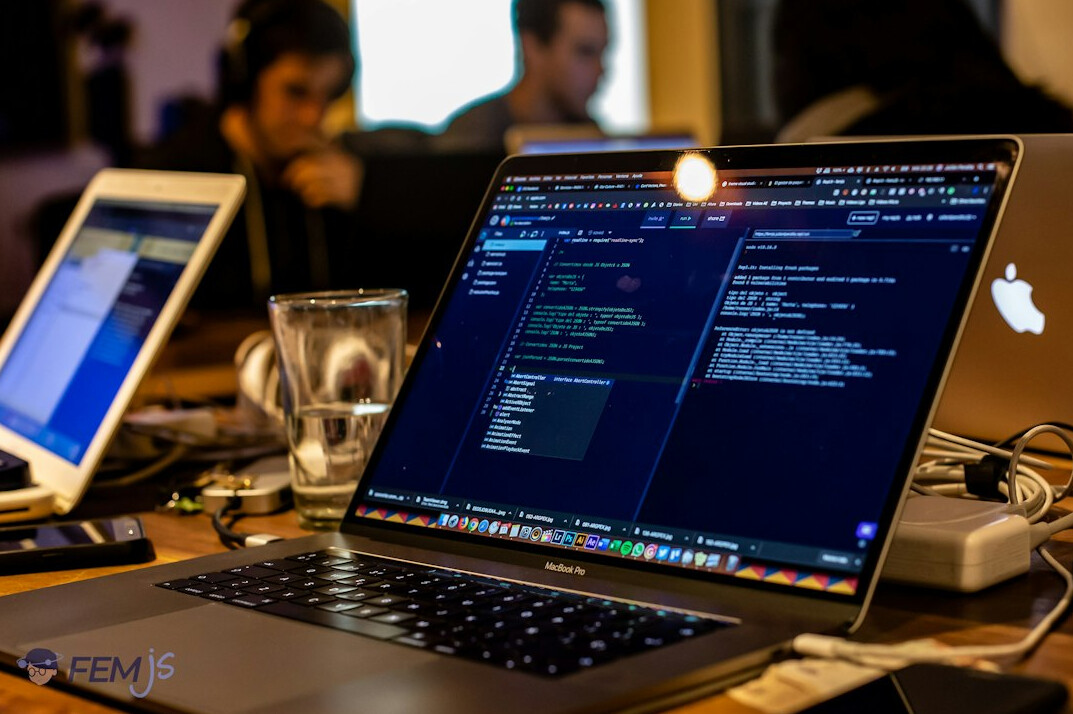 diverse group coding on laptops